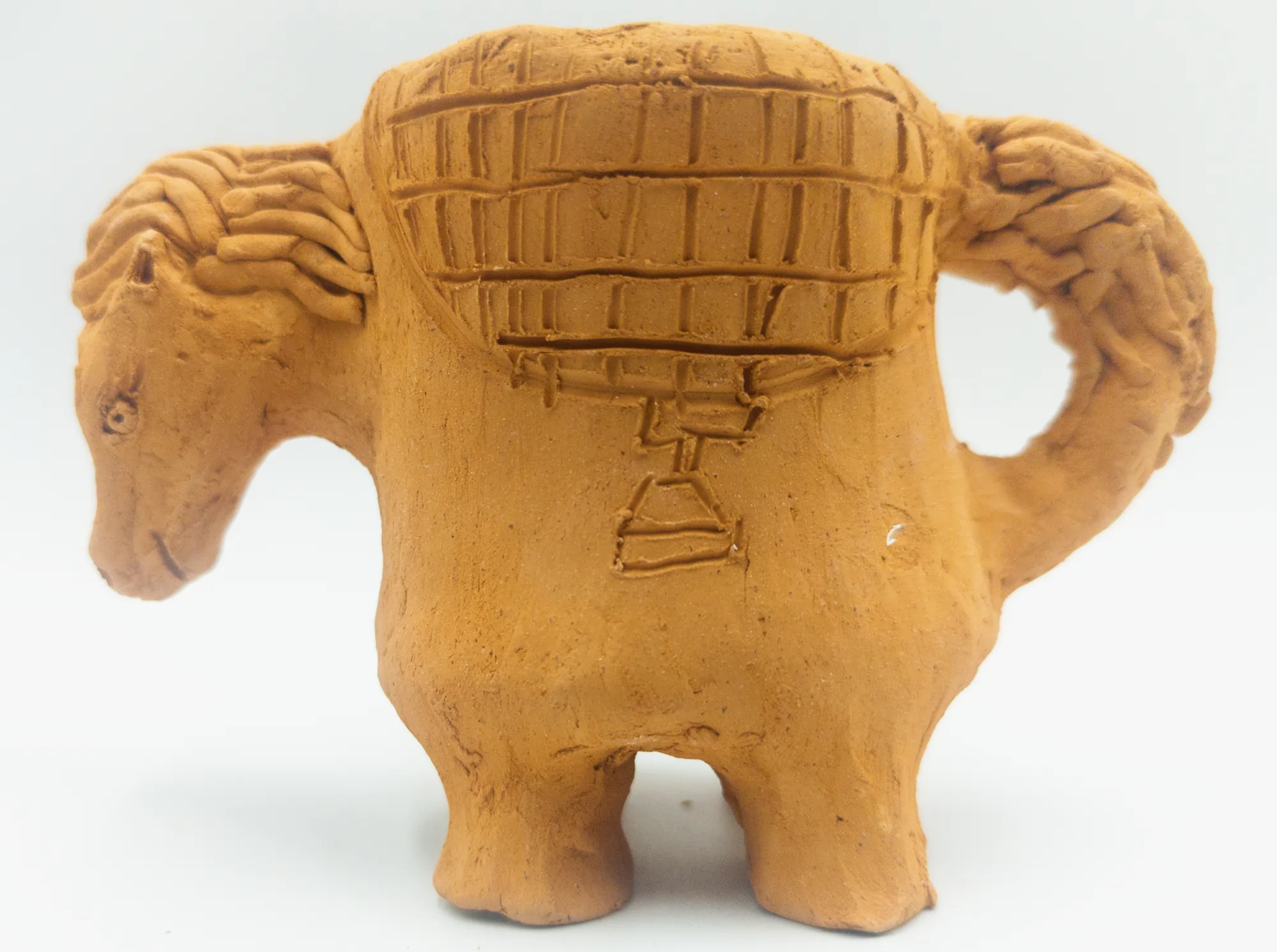 Horse-shaped ceramic cup viewed from the opposite side, showing the saddle and curved tail-handle.