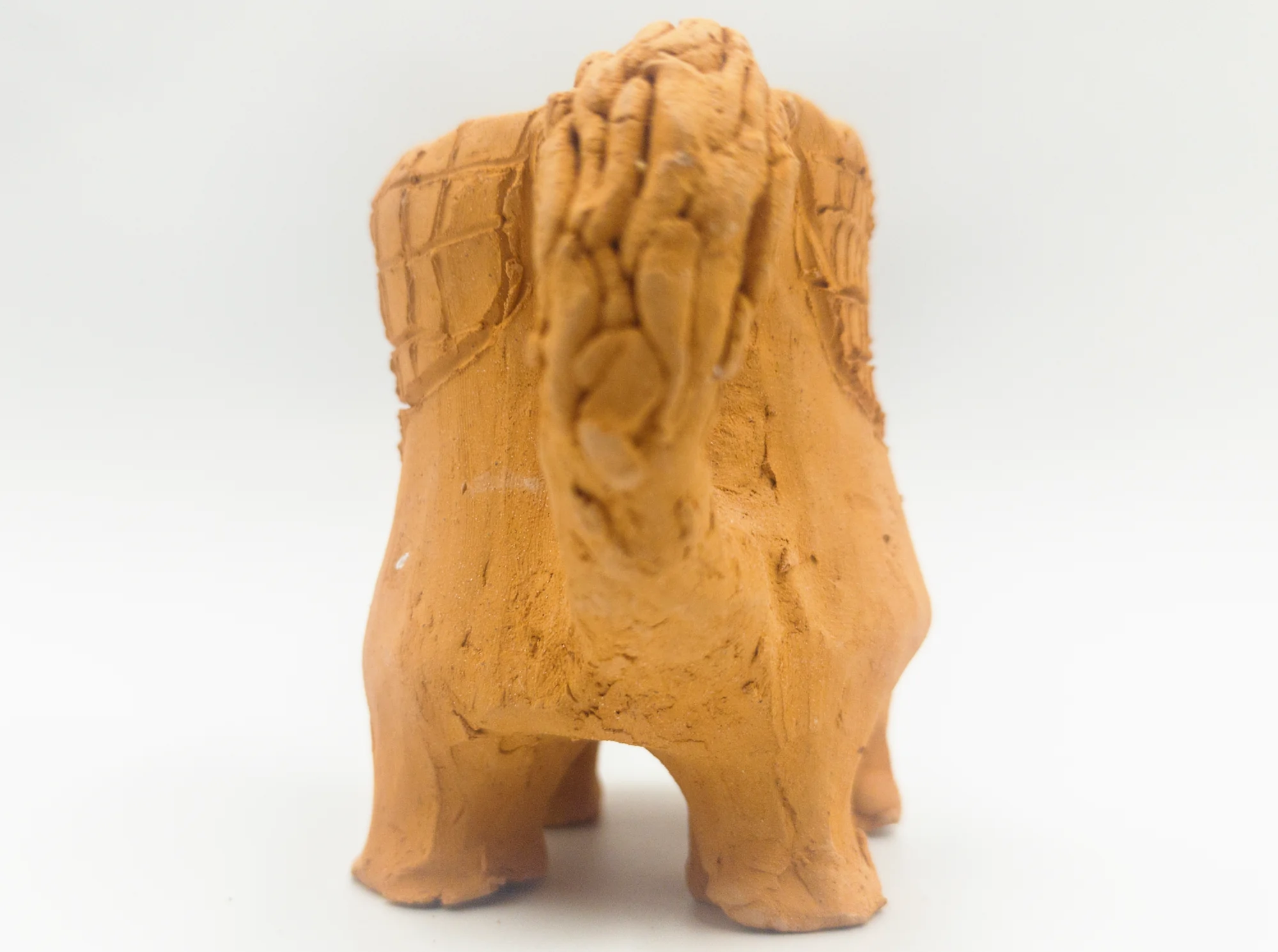 Horse-shaped ceramic cup, rear view showing the legs, tail and curved handle.