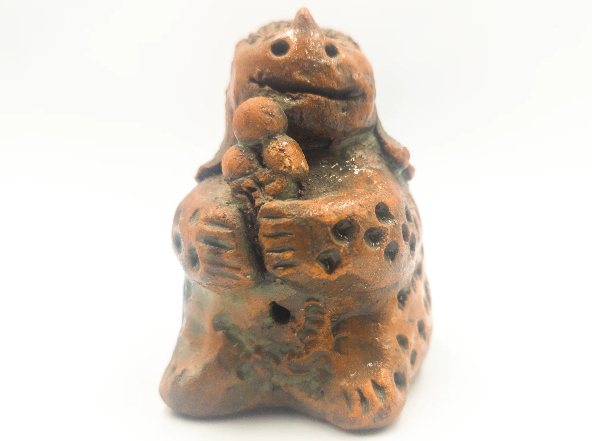 Glazed ceramic dinosaur holding an ice cream cone, front view.