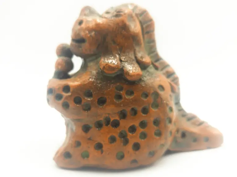 Glazed ceramic dinosaur holding an ice cream cone, a work by Slava Romanenko.