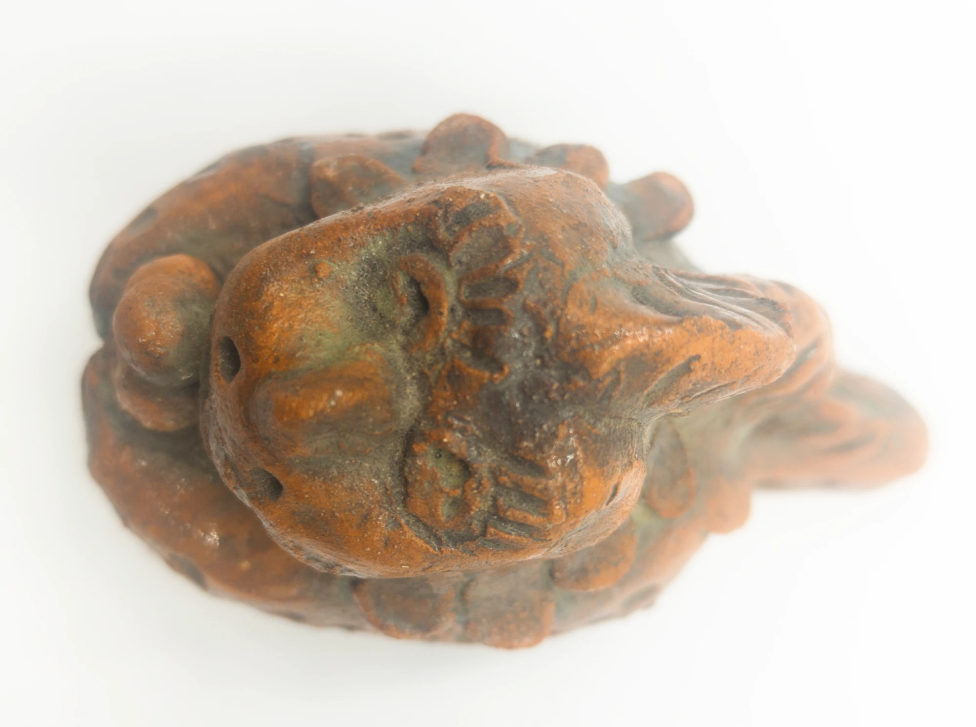 Ceramic dinosaur with ice cream seen from above, showing its head, front limbs, body and tail.