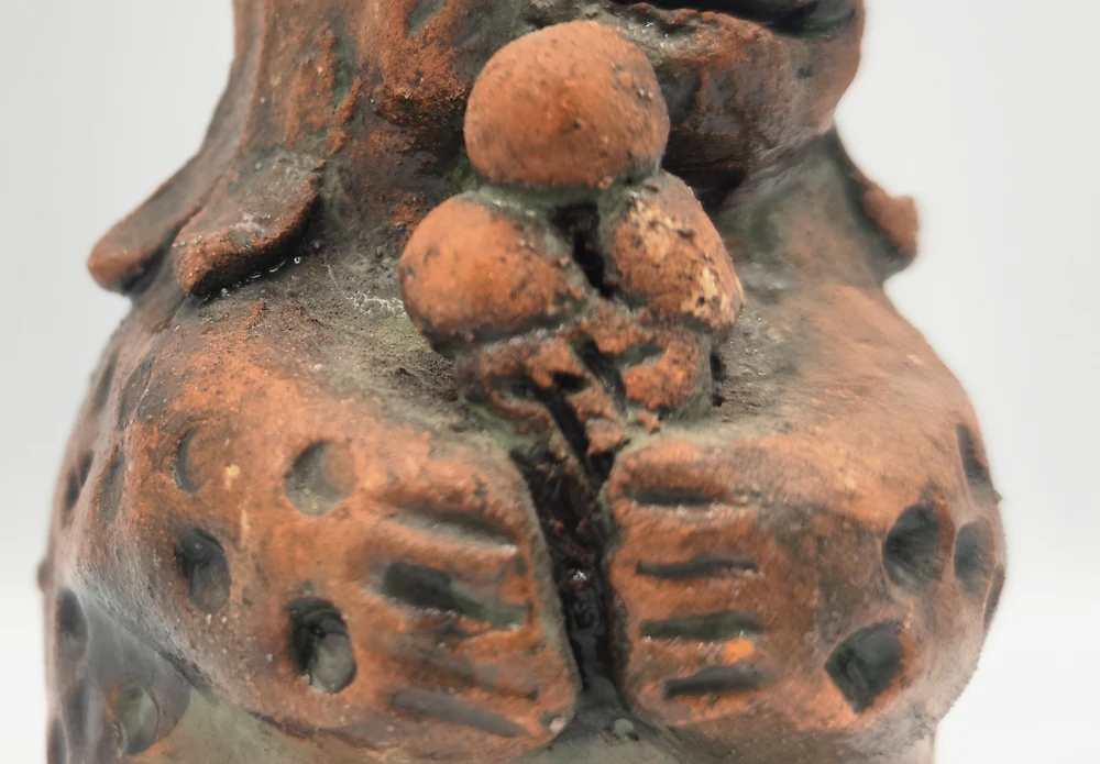 Close-up of three scoops of ice cream in a waffle cone held by the ceramic dinosaur.
