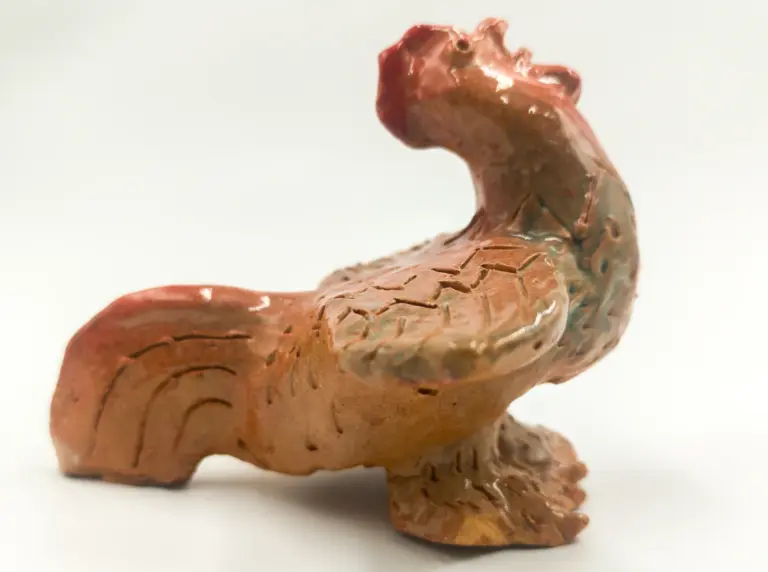Glazed ceramic rooster with an outstretched wing, its head tilted back and its tail acting as a support, a work by Slava Romanenko.